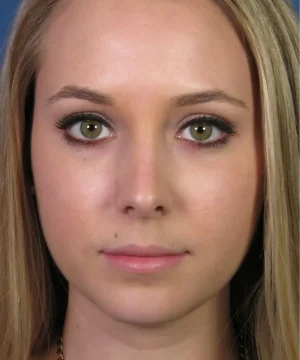 A woman with long blonde hair looks directly at the camera against a plain background.