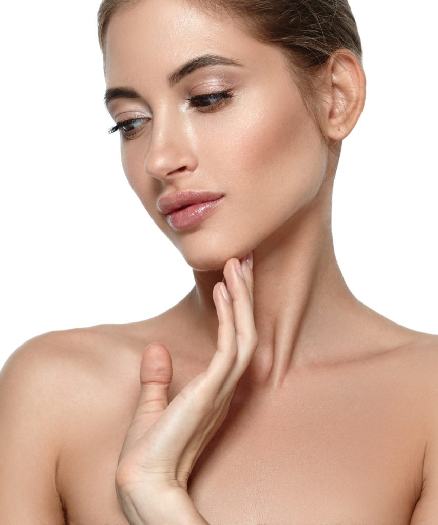 A woman with neutral makeup looks down, touching her chin with one hand against a plain white background.